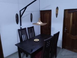 a dining room with a table and chairs and a light at Le perchoir bleu in Lomé