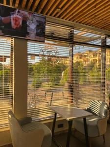 a room with a table and chairs and a large window at Caspian Marine Hotel in Aktau