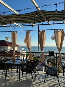 a patio with a table and chairs and the ocean at Caspian Marine Hotel in Aktau