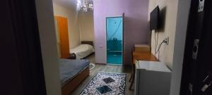 a room with two beds and a door to a bathroom at Гостевой дом RICH in Bosteri