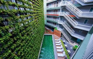 an apartment building with a green wall at Cross Vibe Chiang Mai Decem, Nimman in Chiang Mai