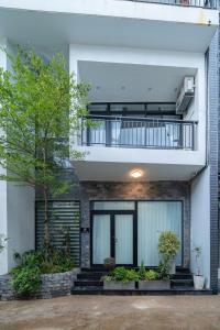 a modern house with a balcony and plants at Dreams Boutique House in Hue City Center in Hue