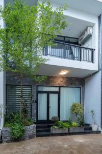 a house with a balcony and a tree at Dreams Boutique House in Hue City Center in Hue +4 photos