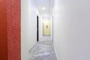 a hallway with white walls and a door in a room at PL Lodge in Pune