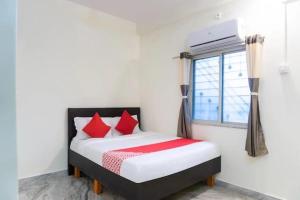 a bedroom with a bed with red pillows and a window at PL Lodge in Pune