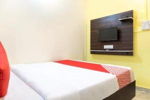 a bedroom with a bed and a tv on the wall at PL Lodge in Pune