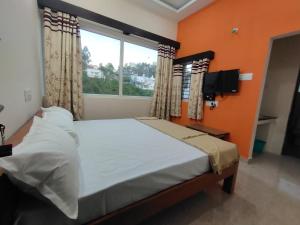 a bedroom with a large bed with a window at Grandwood Coco Resort Yercaud in Yercaud
