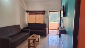 a living room with a couch and a table at Grandwood Coco Resort Yercaud in Yercaud