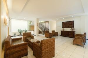 a living room with wicker furniture and a staircase at RedDoorz near Gubeng Station Surabaya in Bagongpatar