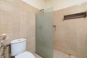 a bathroom with a toilet and a glass shower stall at RedDoorz near Gubeng Station Surabaya in Bagongpatar +29 photos