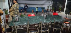 a table and chairs with a green table and red chairs at Grandwood Coco Resort Yercaud in Yercaud