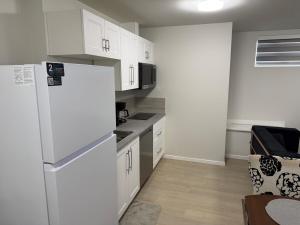 a kitchen with white cabinets and a white refrigerator at Dans luxury suite in Winnipeg +23 photos
