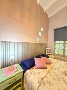 a bedroom with a bed with pink pillows on it at Casa amplia, cómoda en Cataratas con piscina compartida, parrilla, cochera, wifi in Puerto Iguazú +37 photos