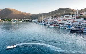 a group of boats docked in a harbor with houses at Kea Harbor 2 in Korissia +10 photos
