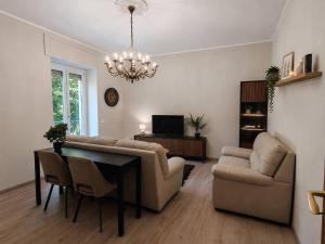 a living room with a couch and a table and chairs at Cozy apartment overlooking the main square in Orsogna
