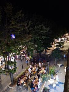 a group of people sitting at tables in a park at Cozy apartment overlooking the main square in Orsogna