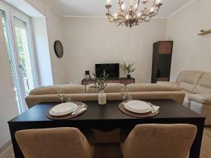 a living room with a table and a couch at Cozy apartment overlooking the main square in Orsogna
