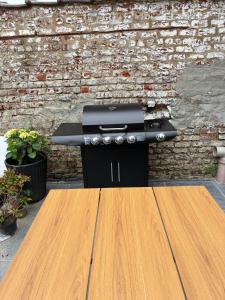 a barbecue grill sitting in front of a brick wall at Tastefully-decorated bedroom with garden access in Brussels