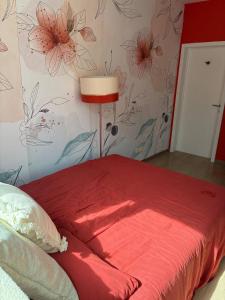 a bedroom with a red bed with flowers on the wall at Tastefully-decorated bedroom with garden access in Brussels +3 photos