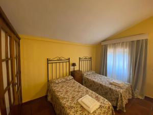 two beds in a room with yellow walls and a window at Detached 4 Bedroom Villa with Pool in Valencia de Alcántara +23 photos