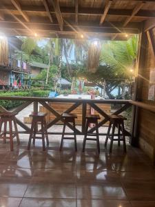 a large wooden table with chairs in a patio at Hotel Meraki Nuqui in Nuquí