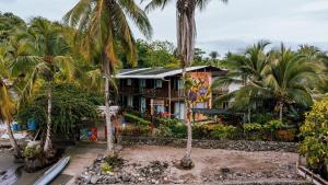 a house with palm trees in front of it at Hotel Meraki Nuqui in Nuquí
