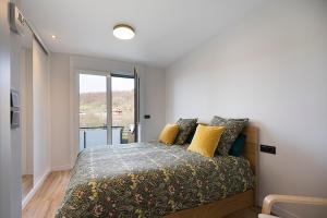 a bedroom with a bed with yellow pillows and a window at CasaGurutze in Elizalde