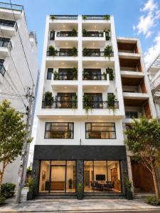 a white building with windows and plants on it at Samaki Home in Ho Chi Minh City