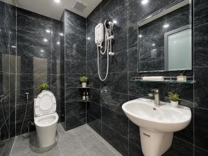 a bathroom with a sink and a toilet and a mirror at Samaki Home in Ho Chi Minh City