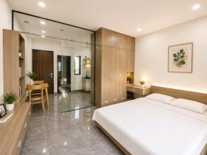 a bedroom with a large white bed and a table at Samaki Home in Ho Chi Minh City