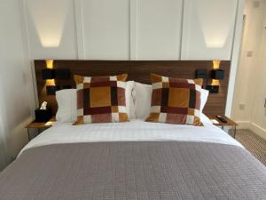 a bedroom with a large bed with two pillows at Bromielaw Room Only Accommodation in Seahouses