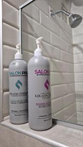 two bottles of sanon cleaning products sitting on a shelf in a bathroom at Loft type apartment premium style with pool in Barranquilla +7 photos