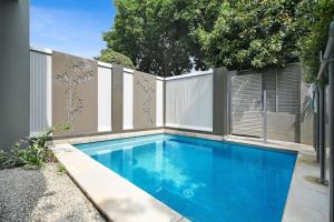 a swimming pool in front of a fence at Coastal Chic with Heated Pool Quiet Location in Sunshine Beach +4 photos