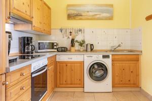 a kitchen with a washer and dryer at Seehaus in Bojendorf