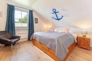 a bedroom with a bed and a chair and a window at Seehaus in Bojendorf