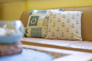 a couch with a pillow on top of it at Seehaus in Bojendorf +22 photos
