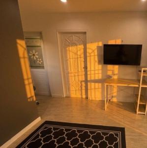a living room with a television and a door at Sunset tiny house near fisherman village in Bophut