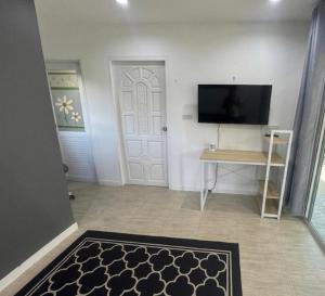 a hallway with a door with a television and a rug at Sunset tiny house near fisherman village in Bophut +1 photo