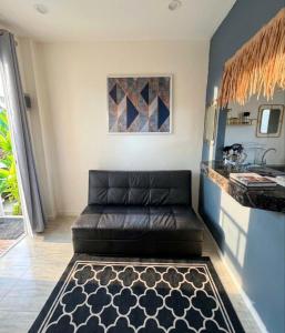 a leather couch in a living room with a counter at Sunset tiny house near fisherman village in Bophut