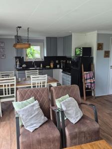 a living room with two chairs and a kitchen at Het ooievaarsnest in Warmond