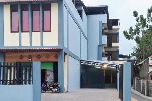 a blue and white building with a motorcycle parked outside at Urbanview Hotel Maharani Garut in Cireungit