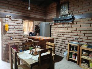 a kitchen with a wooden table and a refrigerator at Cabaña El Fresno in La Petaca +13 photos