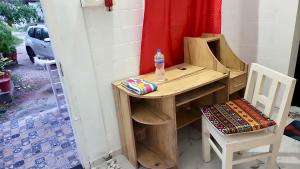 a desk and a chair with a bottle of water on it at Heinrich Wolfi Private Cotege in Pattiyūrgrāmam
