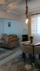 a living room with a table and a couch at Imani staycations Diani in Diani Beach