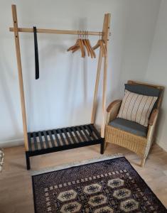 a porch swing with a chair and a rug at Hotel Damm in Aalborg