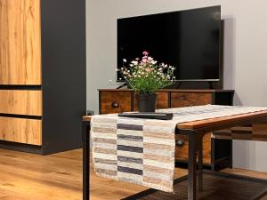 a living room with a table and a tv at Stacja Nałęczów 2 in Nałęczów