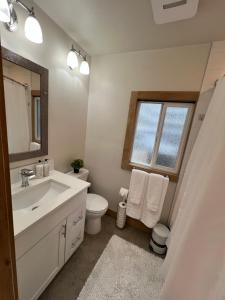 a bathroom with a sink and a toilet and a window at Alki Beach Nest in Seattle +25 photos