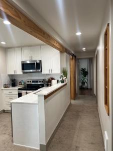 a kitchen with white cabinets and a stove top oven at Alki Beach Nest in Seattle