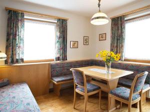 a dining room with a table and chairs and flowers at Edelweiss 206 - Typ B in Fontanella