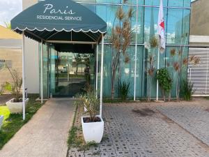 a building with a blue awning and plants in front of it at Lagoa Flats com Super Varanda in Lagoa Santa